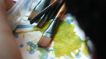 Close up of paintbrushes and a painting video