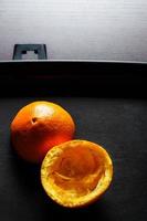 pieles de naranja usadas con luz dramática sobre fondo negro. imagen vertical foto