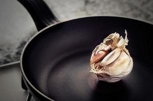 Garlic head in a pan in rustic style. Horizontal image. photo