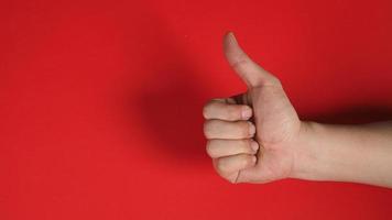 model's forhand doing The thumbs up or like hand sign on red background. photo