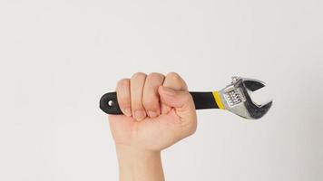 The hand is holding an adjustable wrench isolated on white background photo