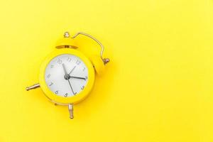 Ringing twin bell vintage classic alarm clock Isolated on yellow colourful trendy modern background. Rest hours time of life good morning night wake up awake concept. Flat lay top view copy space. photo