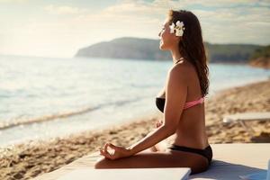 Girl Meditating On The Beach photo