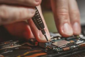 hombre reparando un teléfono móvil foto