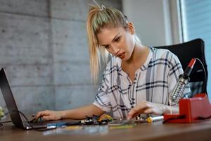 Woman Testing Circuit Board In Her Office photo