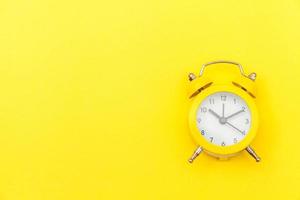 Ringing twin bell vintage classic alarm clock Isolated on yellow colourful trendy modern background. Rest hours time of life good morning night wake up awake concept. Flat lay top view copy space. photo