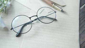 Round framed glasses on letter paper and pen video