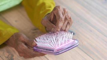 limpeza de escova de cabelo rosa, mãos maduras video