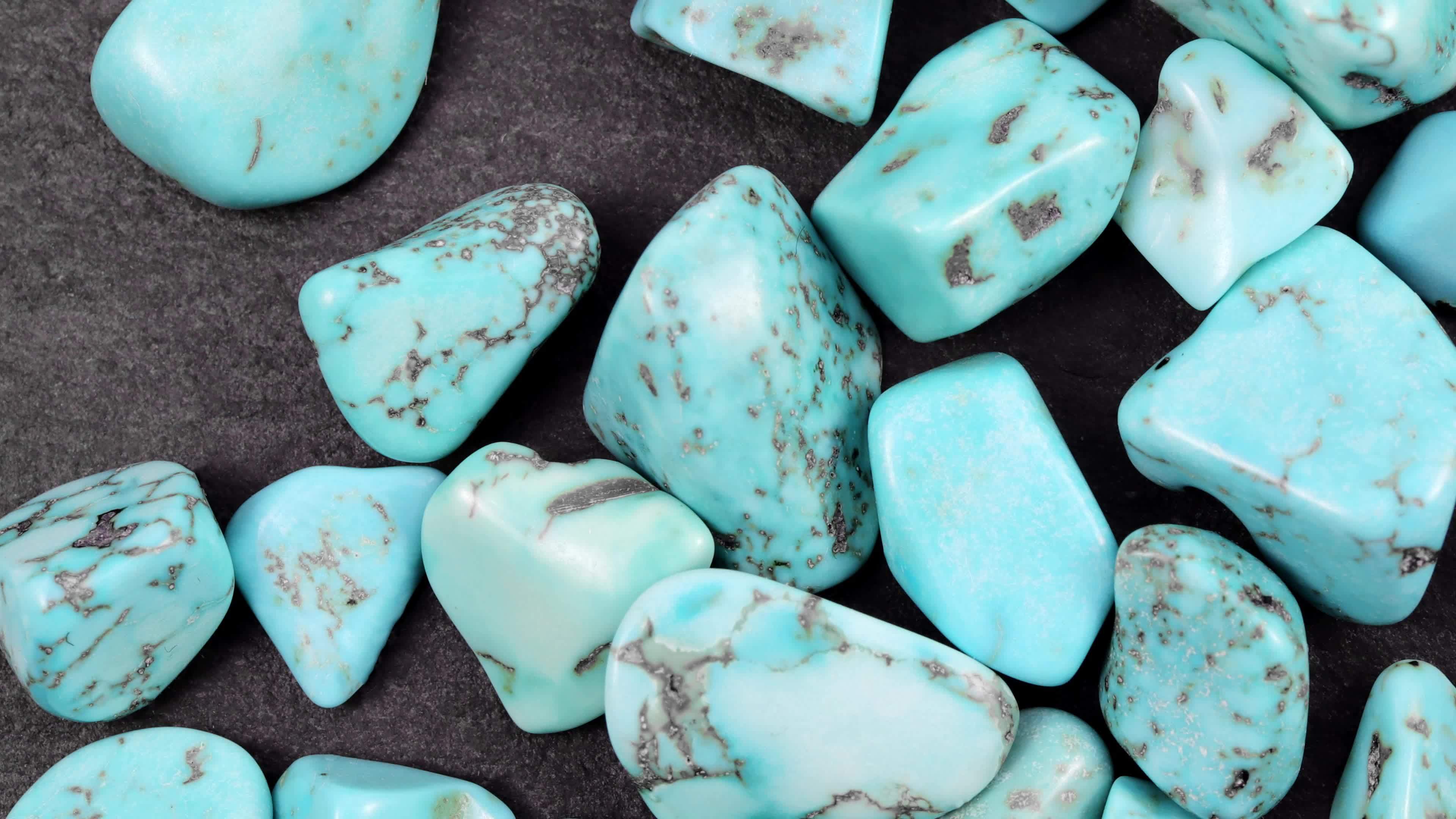 Turquoise heap up jewel stones texture on black stone background