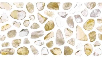 Citrine jewel stones set texture on light white isolated background. Macro closeup. Moving right seamless loop backdrop. video
