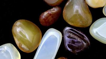 Yellow Agate jewel stones heap up texture on black background. Moving right seamless loop backdrop. video