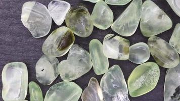 Prehnite jewel heap up texture on black stone background. Moving right seamless loop backdrop. video