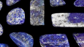 Lapis lazuli rare jewel stones texture on black background. Moving right seamless loop backdrop. video