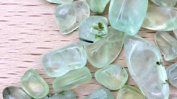 Prehnite jewel heap up on light varnished wood texture. Moving right seamless loop backdrop. video
