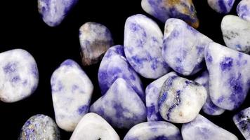 Sodalite heap up jewel stones texture on black background. Moving right seamless loop backdrop. video