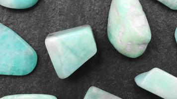 Amazonite rare jewel on black stone texture. Moving right seamless loop backdrop. video