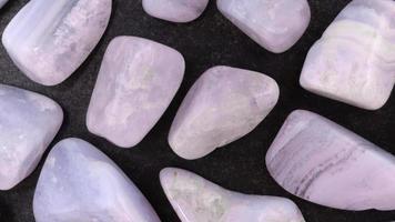 Blue lace agate rare jewel on black stone texture. Moving right seamless loop backdrop. video