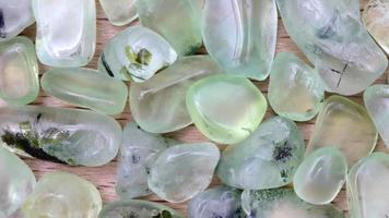Prehnite jewel heap up on light varnished wood texture. Moving right seamless loop backdrop. video