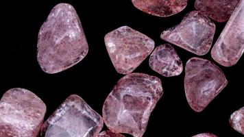 Strawberry quartz heap up jewel stones texture on black background. Moving right seamless loop backdrop. video