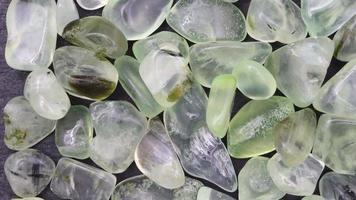 Prehnite jewel heap up texture on black stone background. Moving right seamless loop backdrop. video