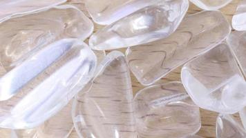 Clear quartz jewel heap on varnished light wood background. Moving right seamless loop backdrop. video