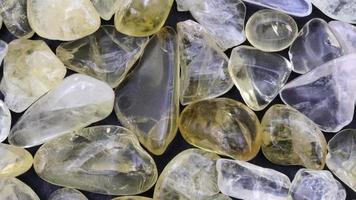 Citrine heap jewel stones texture on black background. Moving right seamless loop backdrop. video