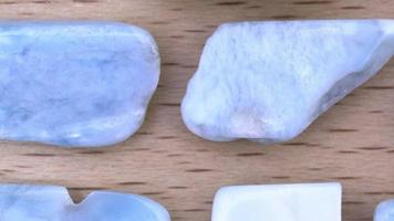 Larimar rare jewel on light varnished wood texture. Moving right seamless loop backdrop. video