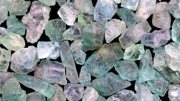 Apatite heap jewel stones texture on black background. Moving right seamless loop backdrop. video