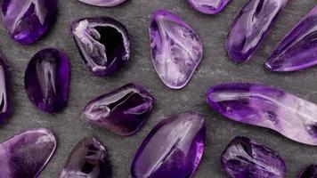 Amethyst seltene Edelsteine Textur auf schwarzem Steinhintergrund. sich nach rechts bewegender nahtloser Schleifenhintergrund. video