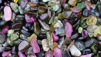 Tourmaline heap jewel stones texture on black background. Moving right seamless loop backdrop. video