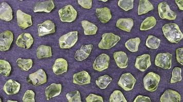 Olivine rare jewel on black stone texture. Moving right seamless loop backdrop. video