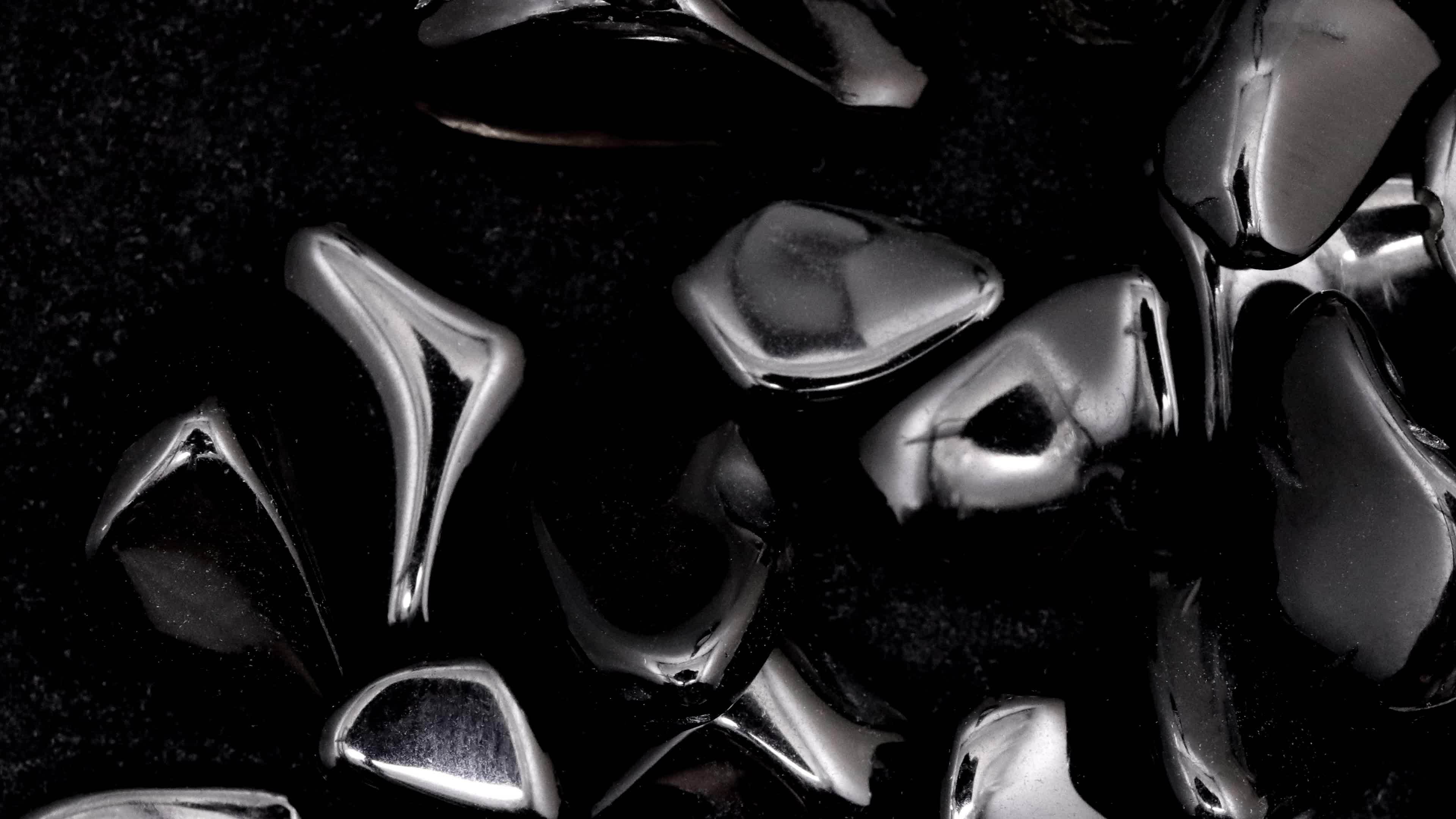 Obsidian heap up jewel stones texture on black background. Moving right