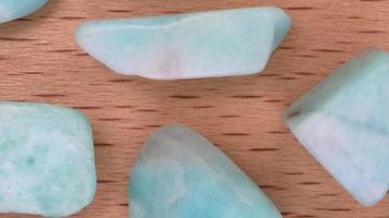 Amazonite rare jewel on light varnished wood texture. Moving right seamless loop backdrop. video
