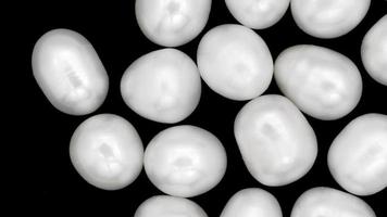 tas de perles texture de pierres de bijou sur fond noir. se déplaçant vers la droite en boucle parfaite. video