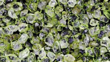 Olivine heap jewel texture background. Pile mineral pebbles nature backdrop. Moving right seamless loop backdrop. video