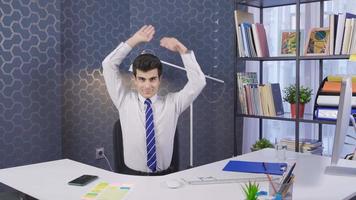 joven empresario haciendo ejercicio en la oficina. joven haciendo ejercicio mirando a la cámara y haciendo ejercicio de estiramiento con los brazos estirados. video