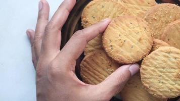 Hand picking up cookie from a container video