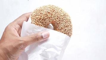 um bagel de gergelim em um saco de papel video