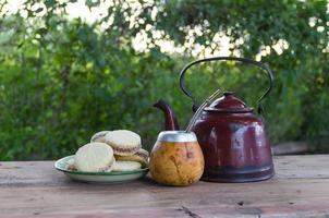 mate y tetera con un plato de alfajores e infusión de yerba mate en el campo argentino foto