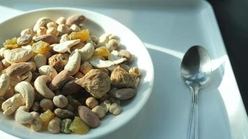 skål av blandad nötter och torkades frukt på tabell miljö med sked video