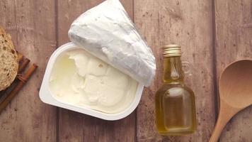 Overhead view of soft cheese oil and bread on wooden surface video