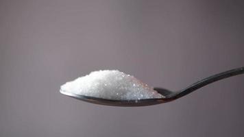 Spoon full of white granulated sugar close up video