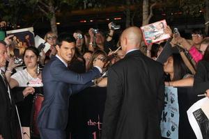 LOS ANGELES, NOV 14 - Taylor Lautner signing autographs at the Twilight - Breaking Dawn Part 1 World Premiere at Nokia Theater at LA LIve on November 14, 2011 in Los Angeles, CA photo