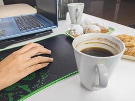 una joven bebió un vaso de café acompañado de bocadillos durante los descansos durante el tiempo de trabajo. foto