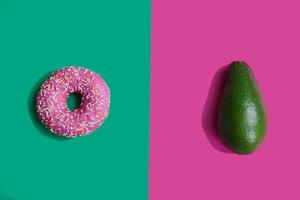 donut and avocado on a bright background. Proper nutrition. Harmful and correct food. Healthy lifestyle. Choice in nutrition photo