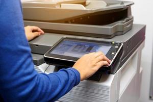 Asian female office worker using a copy machine Copy of documents prepared for the company meeting. Soft and selective focus. photo