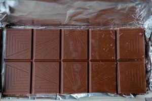Barra libre de chocolate con leche. barra de chocolate en papel de aluminio foto