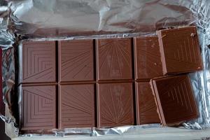 open bar of milk chocolate . chocolate bar in foil photo