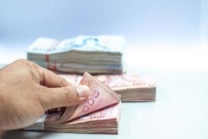 hand of a male bank employee are counting large sums of money to provide financial services to consumers. There is a calculator on the side for ease of work. photo