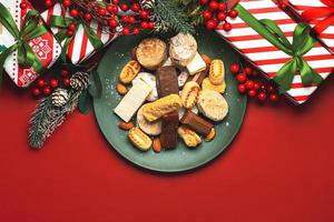 Top view of Nougat christmas sweet,mantecados and polvorones with christmas ornaments on a plate. Assortment of christmas sweets typical in Spain photo